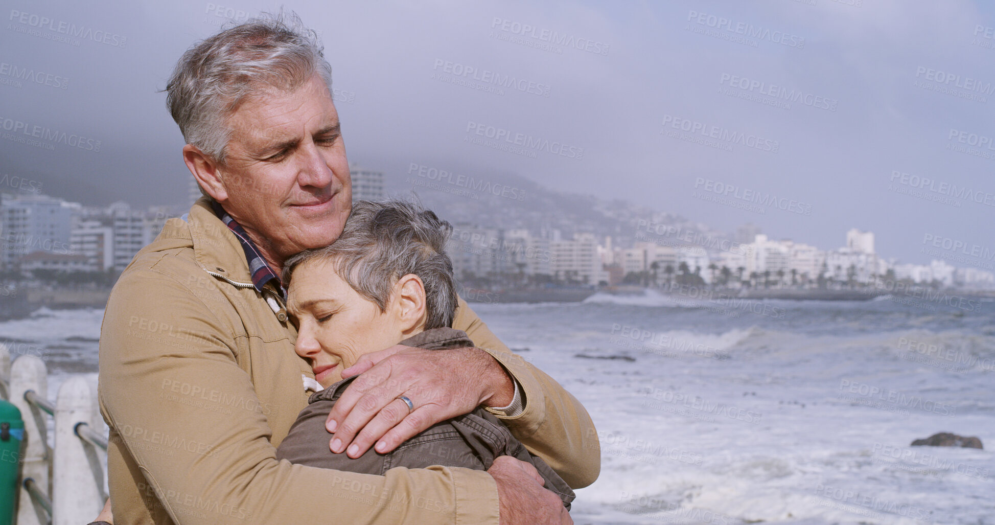 Buy stock photo Mature couple, hug and support by beach, water or ocean for love, partnership and bonding together. Woman, man and embrace in relationship, marriage and care with outdoor, vacation or holiday in city