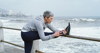 Buy stock photo Mature person, stretching legs and fitness at ocean with peace, flexibility or running preparation. Woman athlete, warm up or muscle tension relief at seaside for exercise, wellness or care in Italy