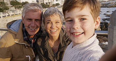 Buy stock photo Grandparents, child and selfie at beach in portrait with smile, memory and bonding on holiday pov. Senior man, woman and boy with photography, care and love with family on vacation with hug in Italy