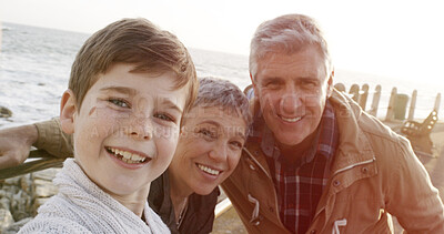 Buy stock photo Beach, grandparents and smile for selfie with boy in winter for bonding, memories and social media in England. Ocean, senior people and happy with kid for care, love and child development on portrait