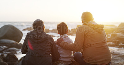 Buy stock photo Family, outdoor and rock by sea with child, sunrise and grandparents at morning in nature on holiday. Vacation, back and beach with idea, calm and thinking of young kid on stone by waves with travel