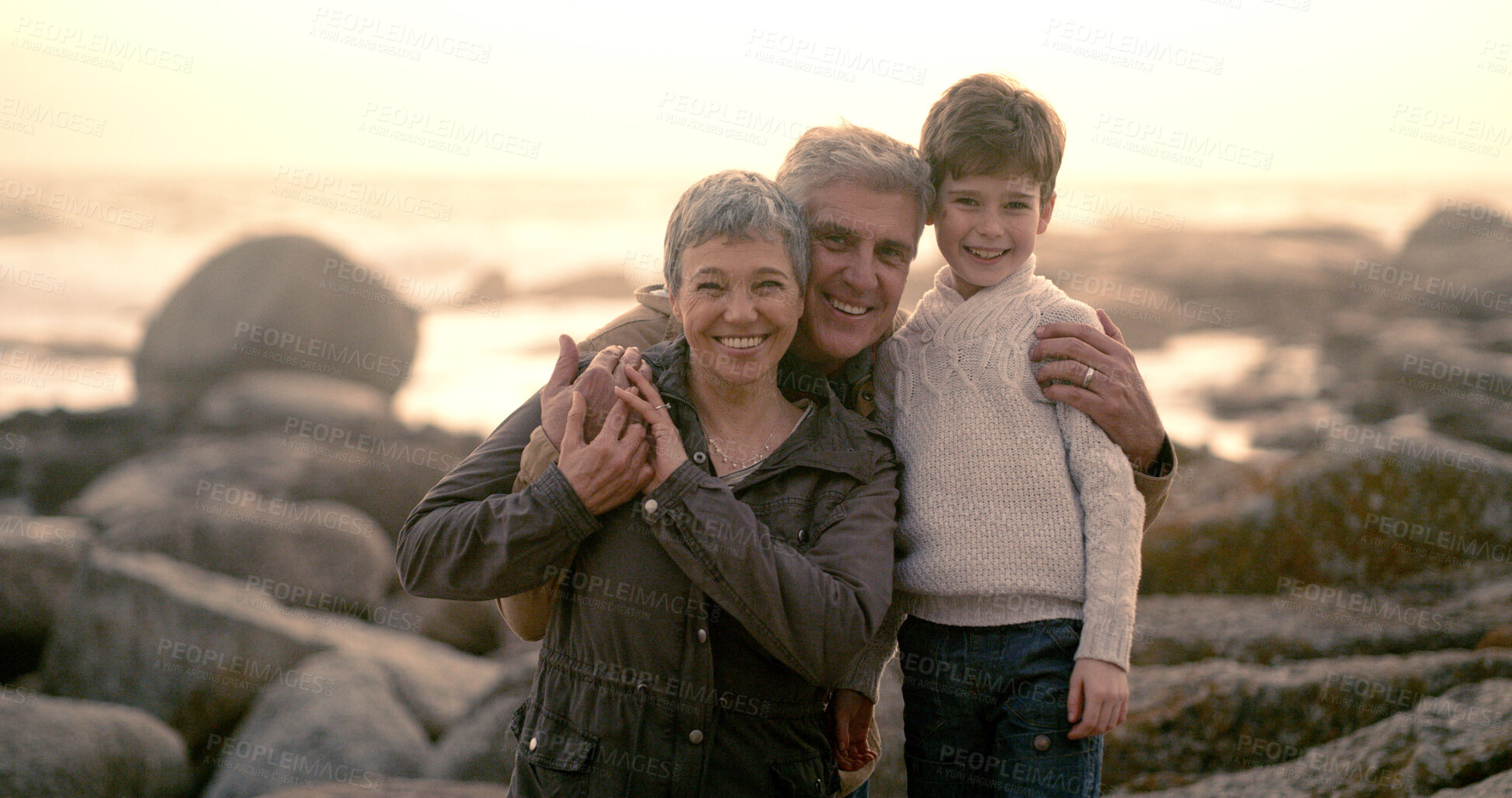 Buy stock photo Sunrise, ocean and portrait of grandparents with kid for bonding, fun weekend and relax at beach. Nature, family and happy boy, grandpa and grandma on holiday, adventure or vacation together