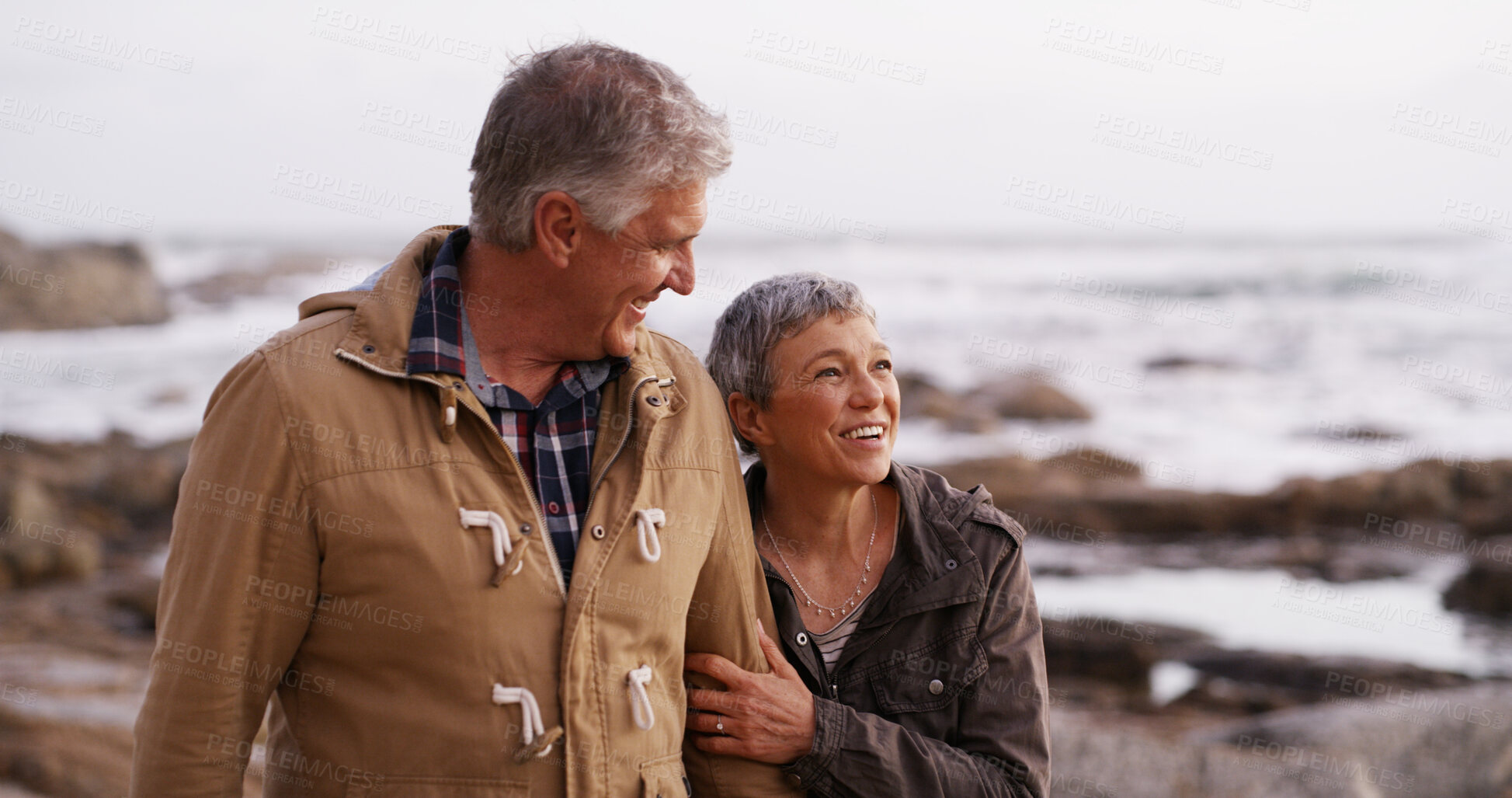 Buy stock photo Happy, holding hands and old couple by ocean walking for bonding, relationship and relax together. Nature, marriage and man and woman by sea talking for romance, commitment and love on weekend