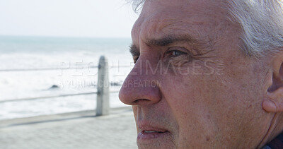 Buy stock photo Sad, beach and mature man with thinking, grief and loss with depression and stress on promenade. Lonely, sea and winter vacation with closeup, memory and bad news by ocean to remember the past