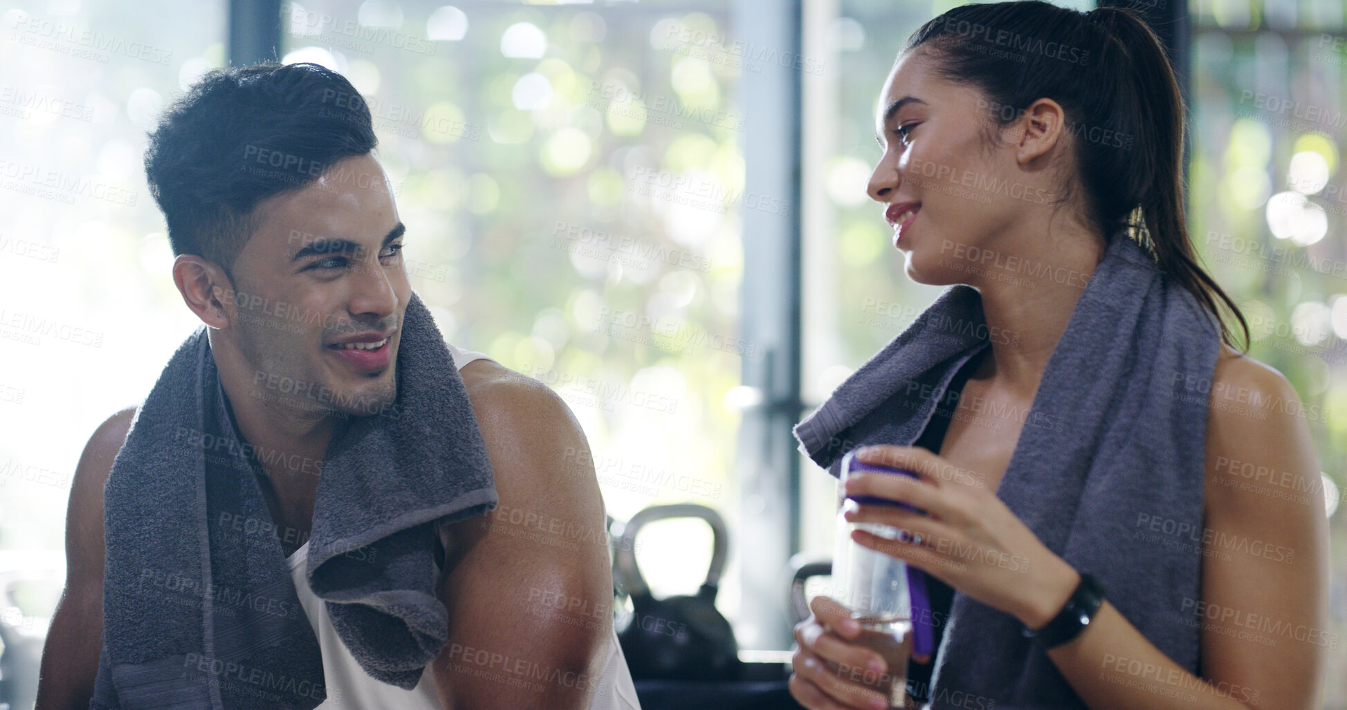 Buy stock photo Happy couple, gym and talking on break, towel and training with rest, exercise and wellness in morning. People, man and woman with partnership, workout and tired at fitness club with conversation