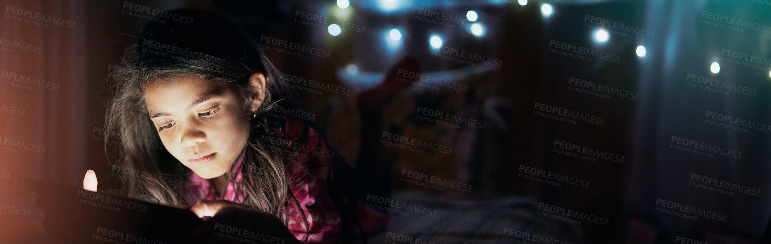 Buy stock photo Shot of a little girl using a digital tablet late at night in her bedroom