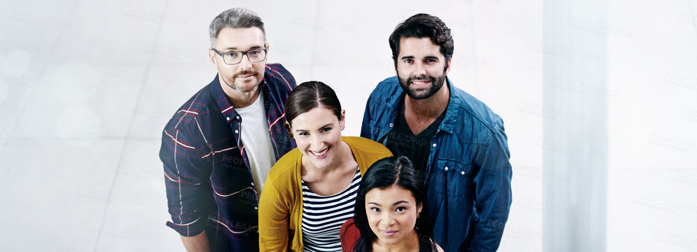Buy stock photo High angle shot of a group of creatives standing together in an office