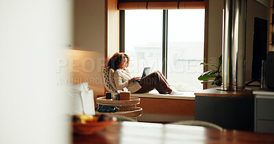 Buy stock photo Woman, laptop and relax by window for comfort, ebook and social media on weekend with website. Female person, subscription and peace in home for lazy day, break and streaming in apartment with movie
