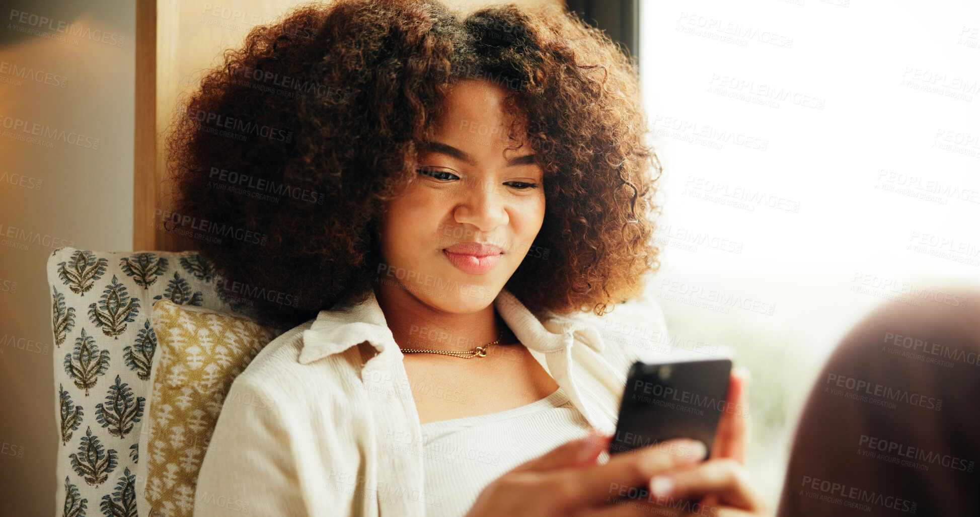 Buy stock photo Woman, smile and relax in home with phone, social media and funny meme in text message. Girl, reading or mobile at living room window for peace, streaming service or comedy platform for entertainment