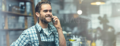 Buy stock photo Shot of a young man using a phone in the store that he works at