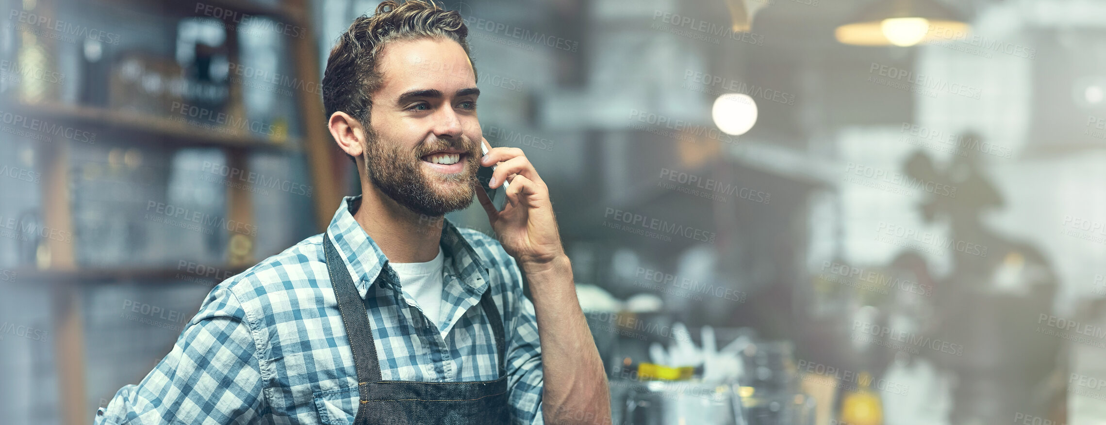 Buy stock photo Shot of a young man using a phone in the store that he works at