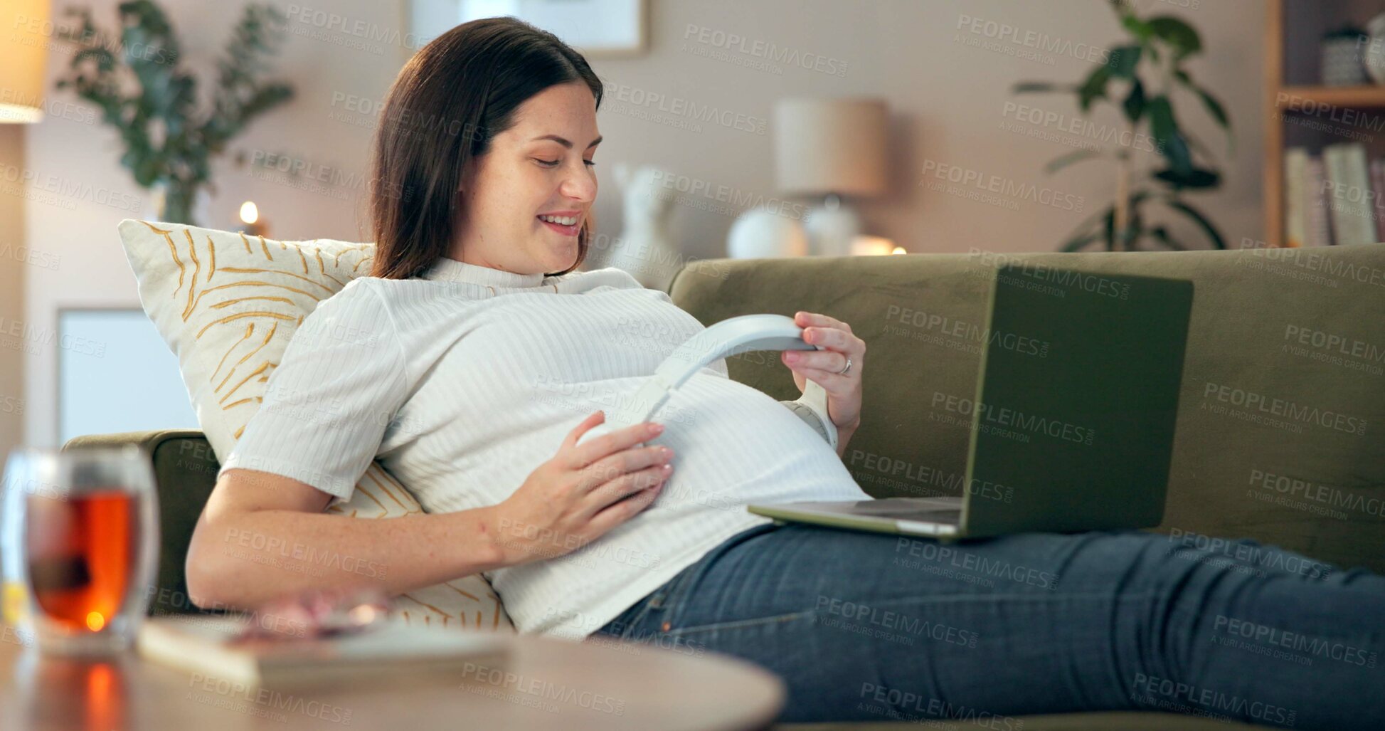 Buy stock photo Headphones, laptop and belly for pregnant woman with sofa, living room and home for baby audio bonding. Music, health and streaming for happy mother with apartment, development and pregnancy wellness