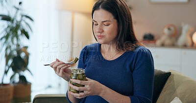 Buy stock photo Home, pregnant woman and relax with pickle for eating, nutrition or wellness for baby development. Sofa, female person or hungry with vegetable for pregnancy, craving or fermented snack for vitamin k