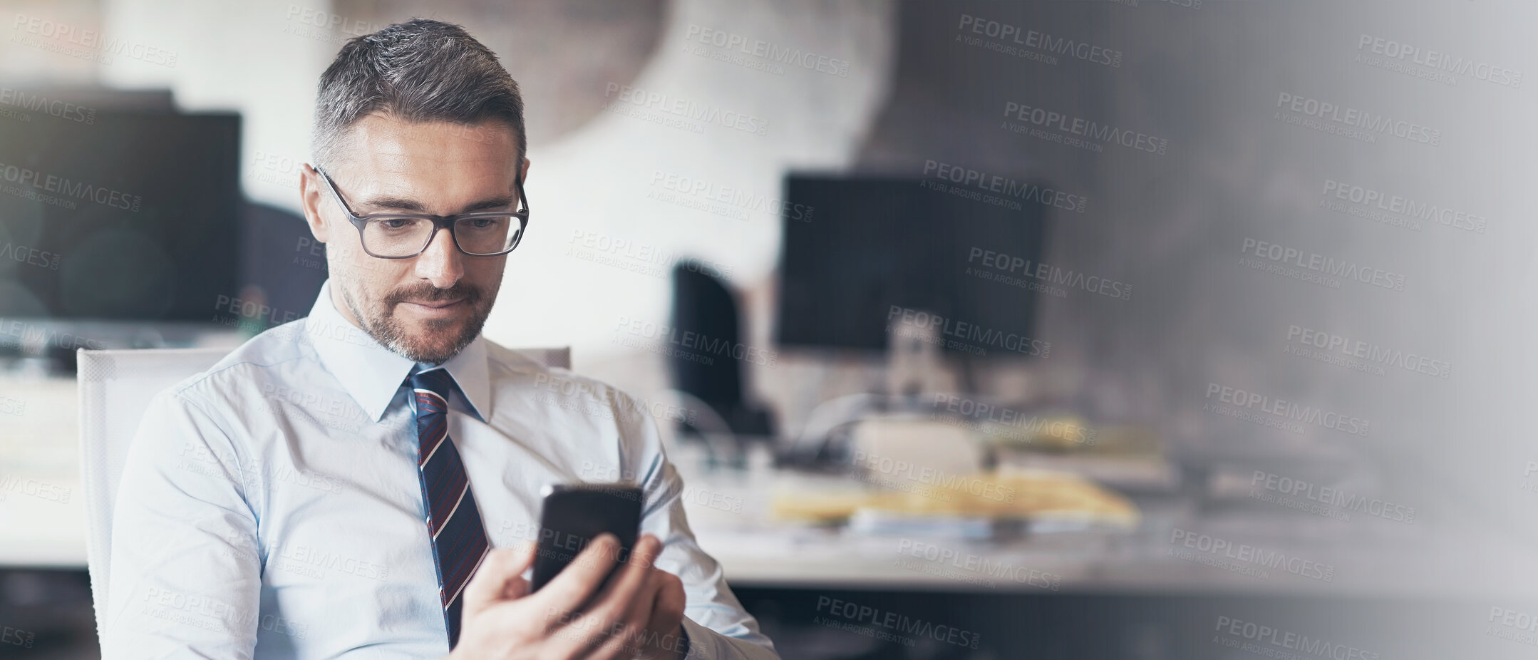 Buy stock photo Cropped shot of a businessman using his cellphone while sitting in his office