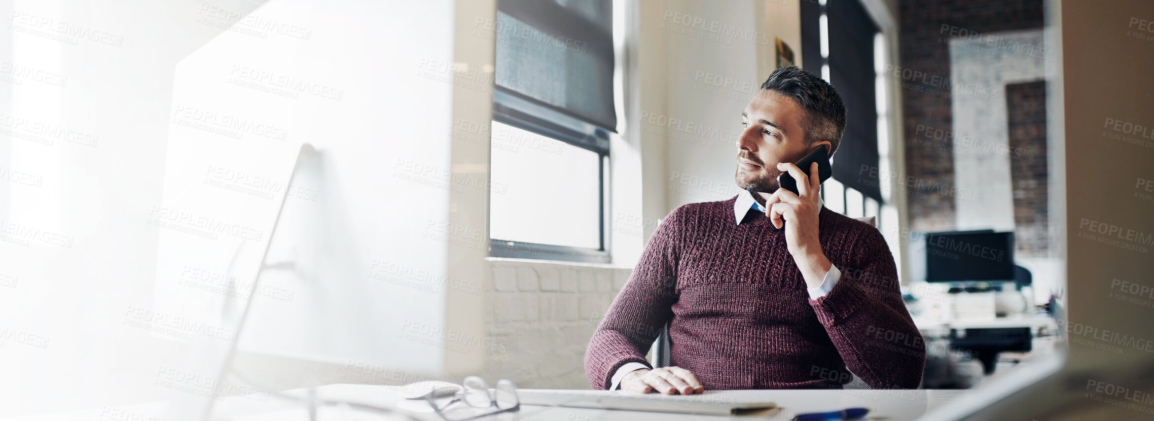 Buy stock photo Shot of a businessman talking on his cellphone while sitting at his desk