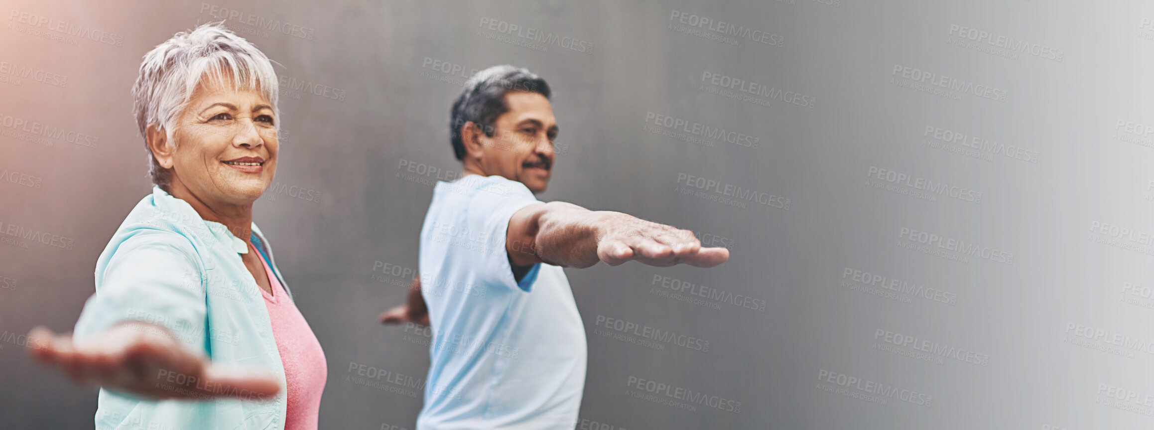 Buy stock photo Shot of a happy older couple practicing yoga together outdoors against a gray background