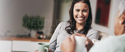 Buy stock photo Shot of a young woman and her mother catching up on the sofa while drinking coffee