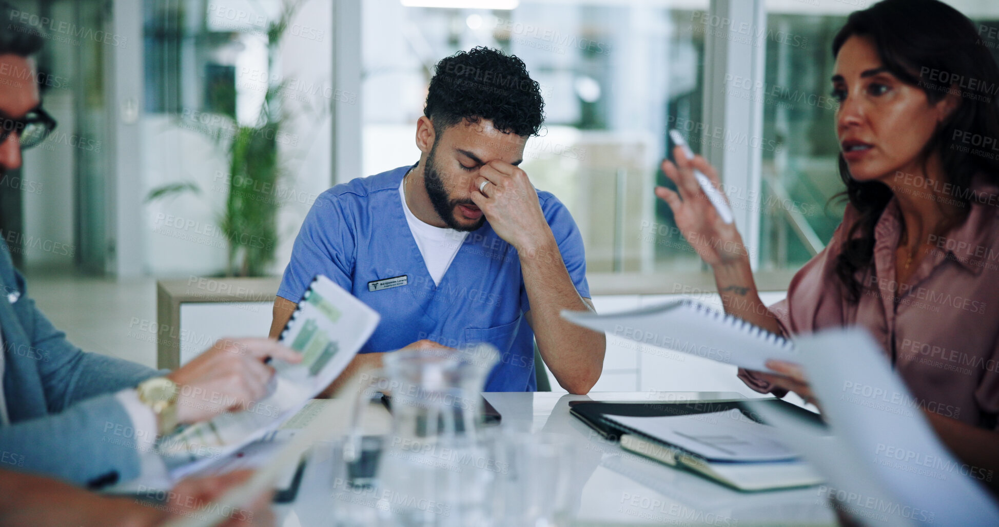 Buy stock photo Man, nurse and headache with stress in meeting for anxiety, overworked or fatigue at hospital. Male person, migraine and burnout with documents in team discussion for bankruptcy, debt or vertigo