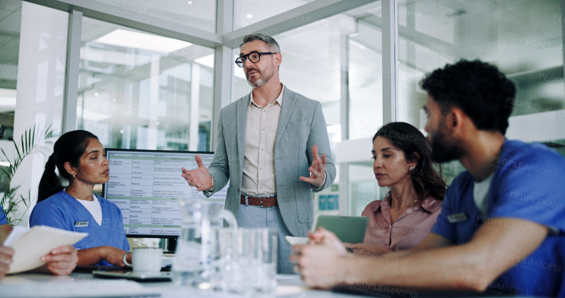 Buy stock photo Man, medical team and meeting with presentation in conference for planning, proposal or discussion at hospital. Male person, speaker or group of healthcare employees listening to executive director