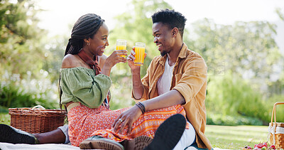 Buy stock photo Nature, picnic and black couple toast with juice on blanket for bonding, relationship and trust outdoors. Dating, drinks and man and woman on weekend for romance, anniversary celebration and love