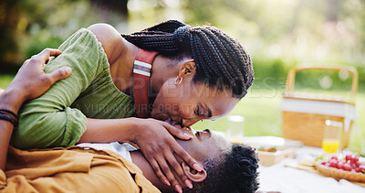 Buy stock photo Love, kiss and black couple at picnic in park for bonding, connection and outdoor adventure on happy weekend. Nature, man and woman on blanket for date together with romantic embrace, smile and trust