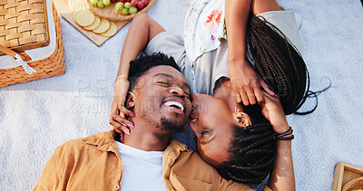 Buy stock photo Above, kiss and smile with black couple and picnic for bonding, happiness and romantic date. Love, support and conversation with man and woman at park for commitment, valentines day and funny