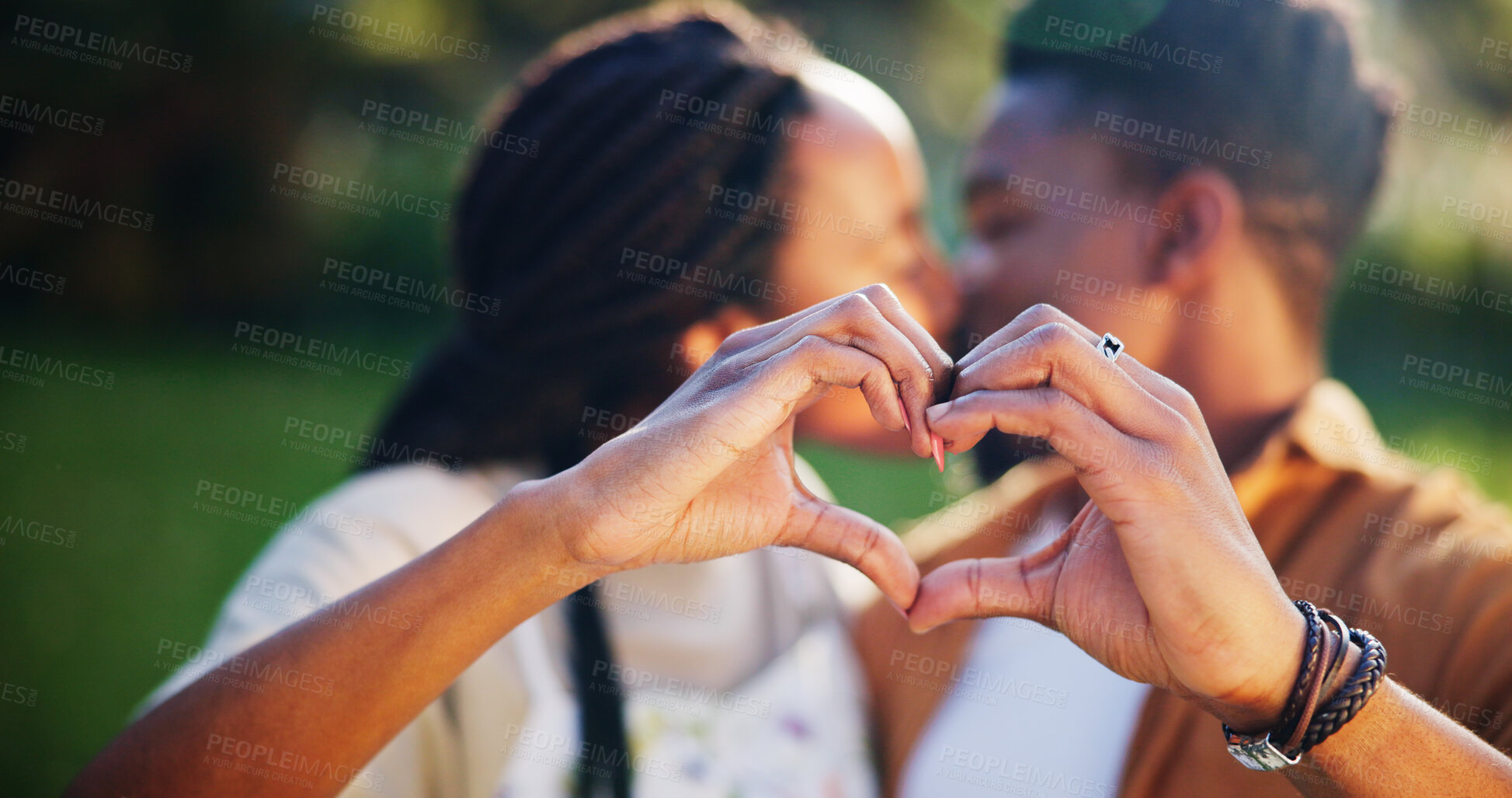 Buy stock photo Black couple, heart and hands with kiss in park with support for love, trust and care outdoor. Garden, icon and emoji sign with people, kindness and save the date together for wedding announcement