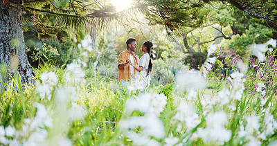 Buy stock photo Dance, flowers and love with black couple in nature for romance, honeymoon date and bonding together. Celebration, happiness and spring with man and woman in park for relationship, support and care
