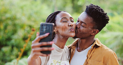 Buy stock photo Black couple, outdoor and selfie with kiss in park with holiday, love and care together with social media and smile. Happy, people and bonding on summer vacation with profile picture in garden on web