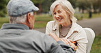 Senior couple, speaking and smile in park for bonding, conversation and commitment together outdoors. Retirement, marriage and mature man and women in nature on bench for love, care and connection