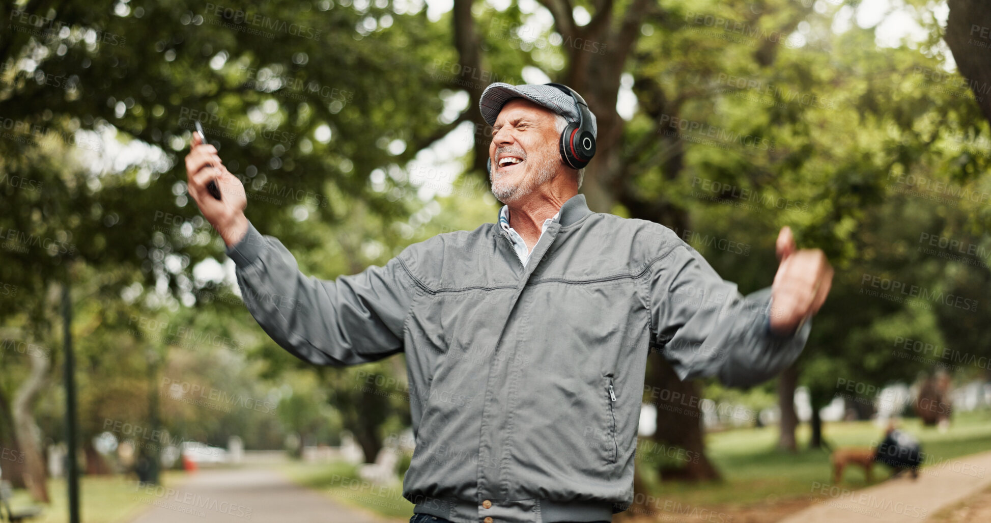 Buy stock photo Headphones, senior man and phone with celebration in park for good news, giveaway winner and gambling bonus. Old person, smartphone and excited in nature for lottery prize or competition notification