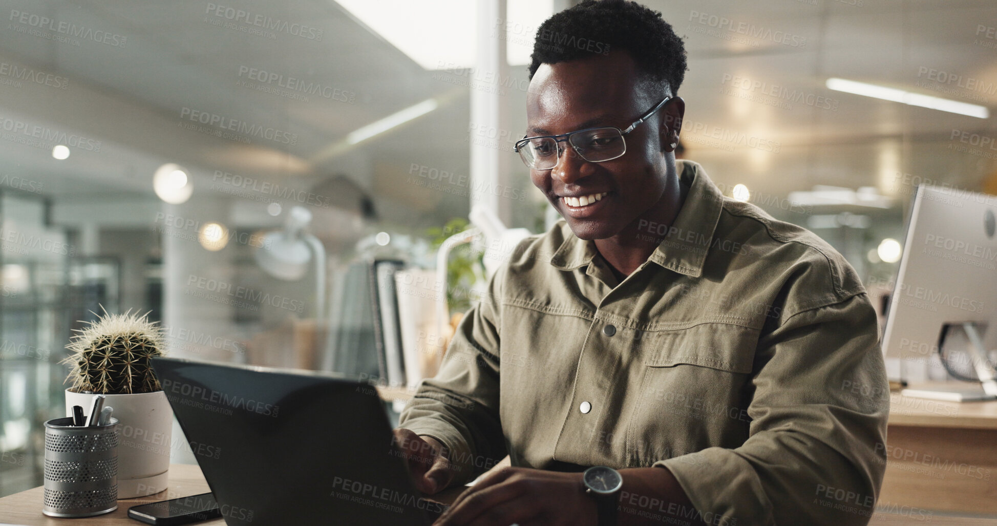 Buy stock photo Black man, office and laptop with typing, research and happiness in working late at night on project. Male person, technology and concentration as web designer in digital agency for online navigation