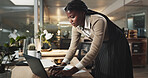 Black woman, laptop and typing at night in office for project, review or deadline at media company. African person, writer and computer for feedback, overtime and editing article at creative agency