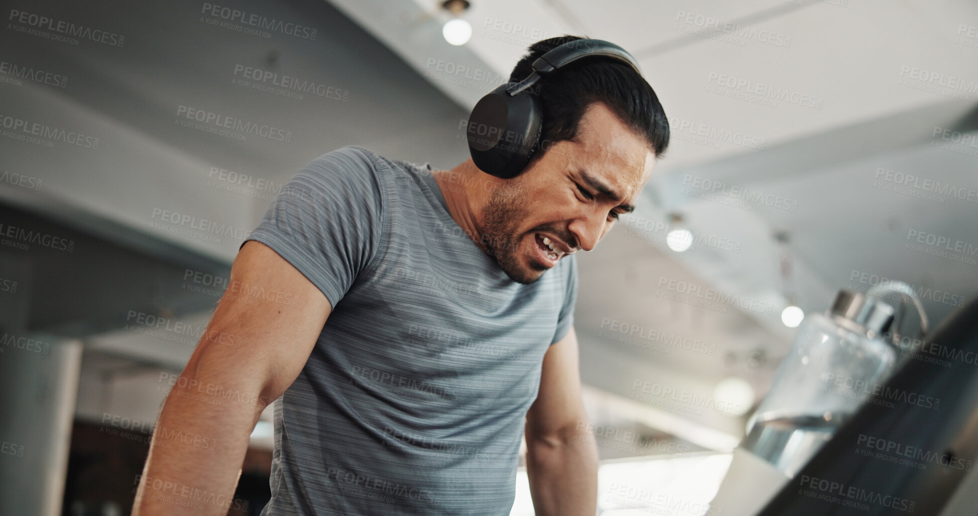 Buy stock photo Tired, treadmill and headphones with man in gym for running, podcast audio and challenge. Fatigue, fitness and exercise with person training in sports center for streaming, workout pain and athlete