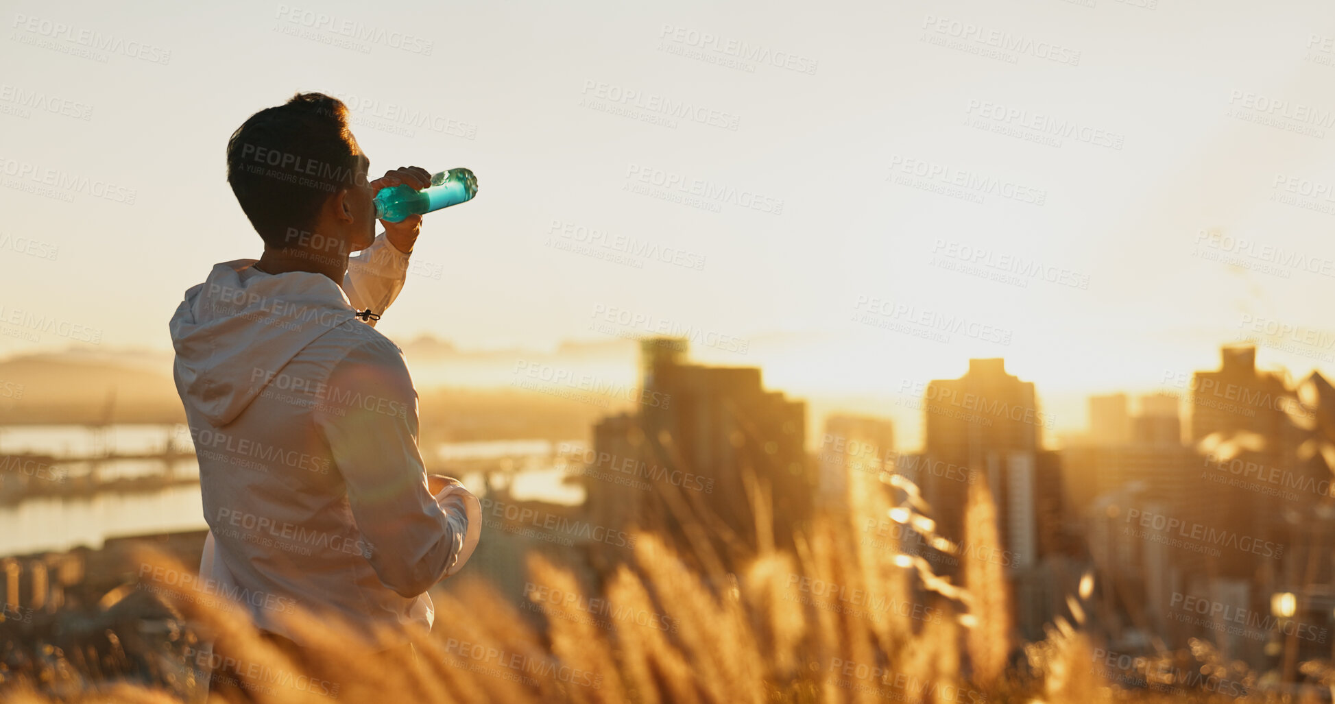 Buy stock photo Man, water and sunset with exercise, break and city view for fitness or cardio workout. Athlete, drinking and training on mountain for wellness, health and summer marathon performance or endurance