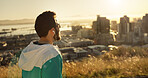 City, fitness and man runner thinking for cardio or marathon training at sunset. Outdoor exercise, earphones and workout with happy athlete person in urban town for health, improvement or wellness