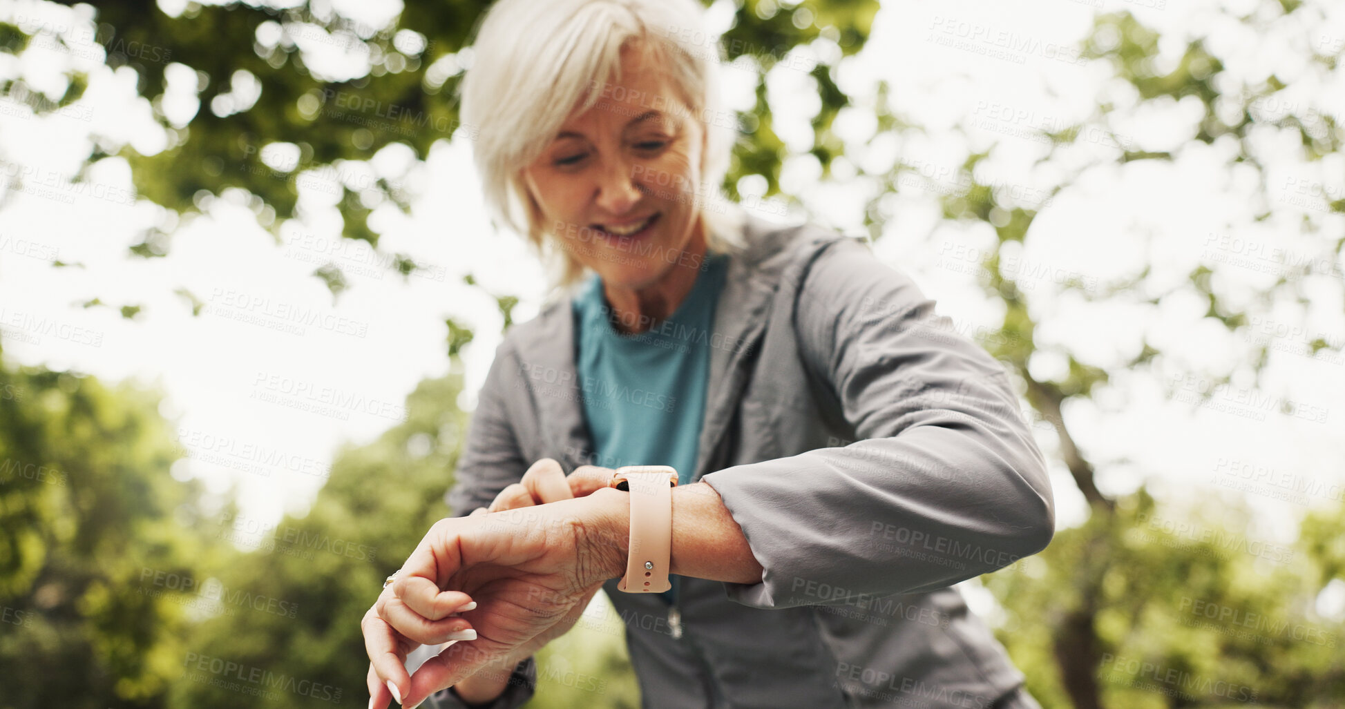 Buy stock photo Fitness, check time and mature woman in park, smile and nature with training, wellness and exercise. Sports, person and runner with watch, outdoor and app to monitor heart rate, practice or challenge