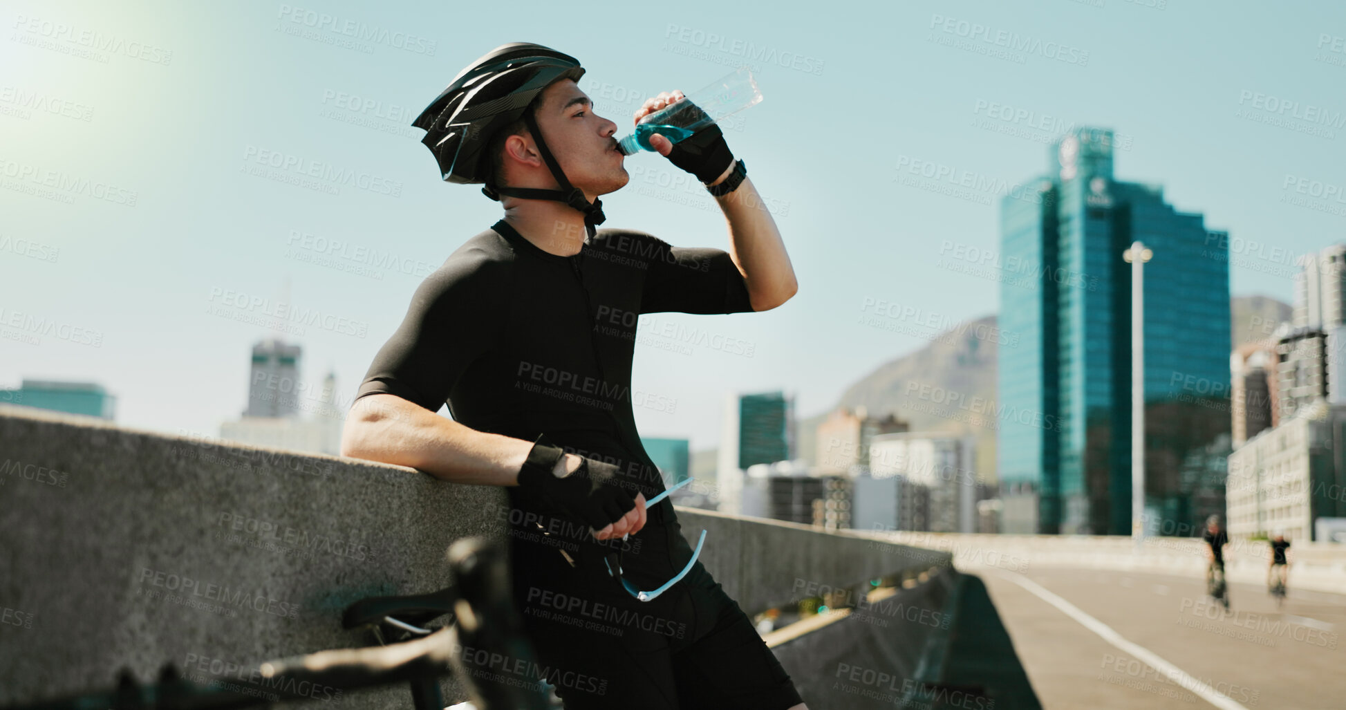 Buy stock photo Drinking water, training and cycling with man in city for triathlon challenge, electrolytes and workout. Wellness, exercise and competition with person and bike for sports, fitness and cardio