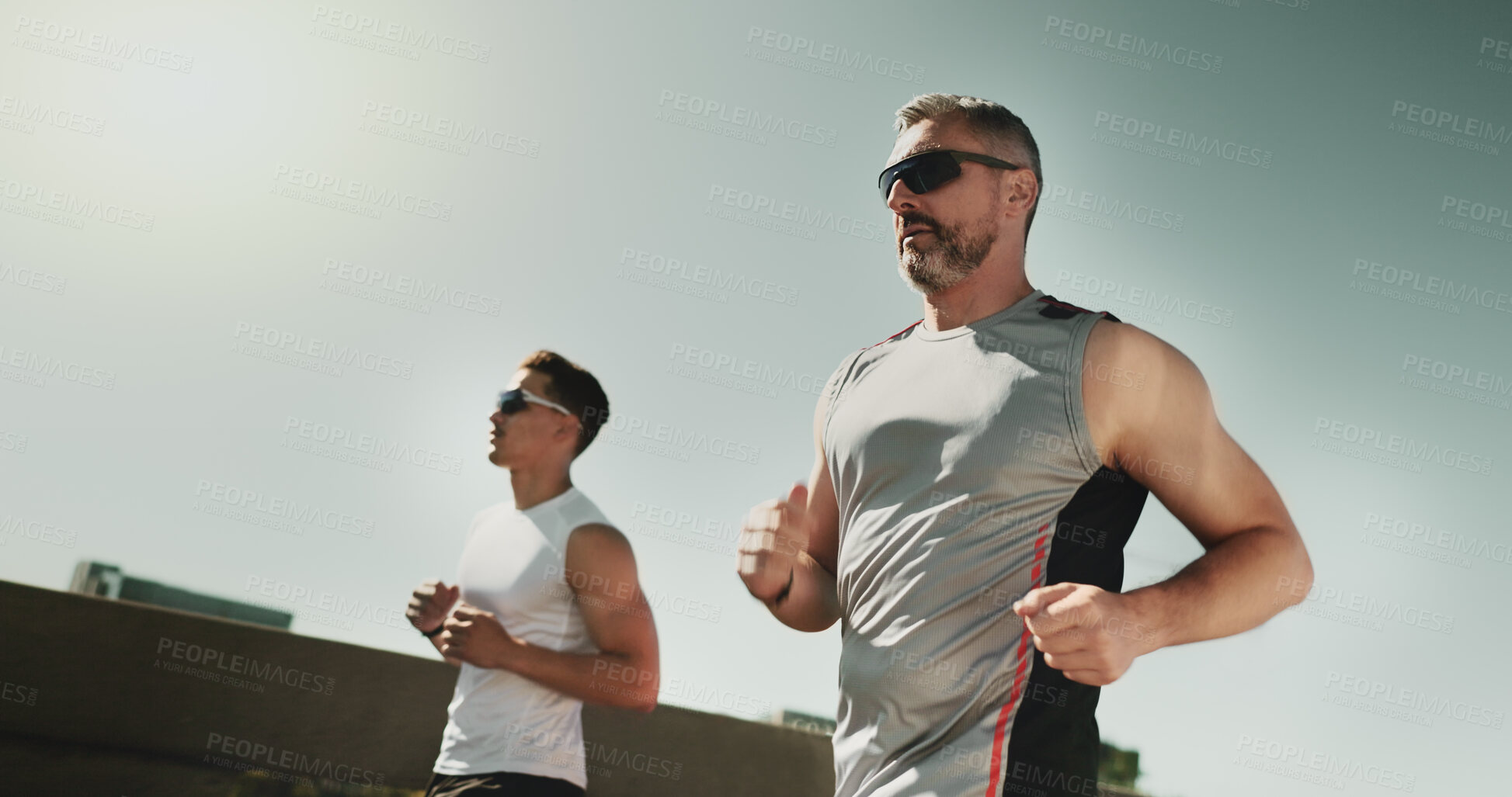 Buy stock photo Men, runner and coach for fitness in city on bridge for training, challenge and low angle with speed on road. People, partnership and exercise in urban street, fast and workout in morning in Germany