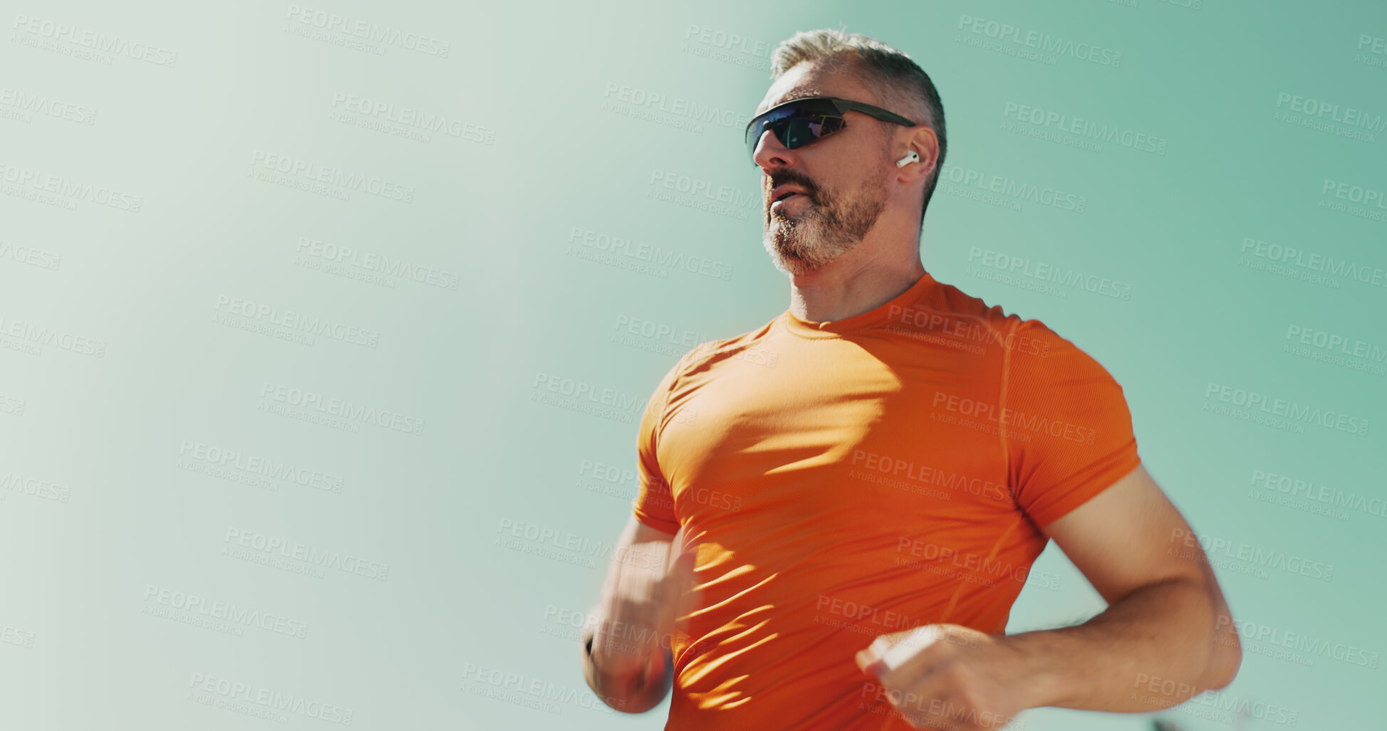 Buy stock photo Man, sky and running with earphones for fitness, streaming music and sunglasses for cardio. Male person, mockup space and athlete for sports workout, hearing song and outdoor for exercise activity