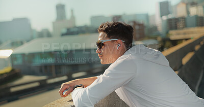 Buy stock photo Fitness, bridge and man with earphones, break and streaming of music, wellness and relax in morning. Outdoor, glasses and routine for health, thinking and person with eyewear, podcast and audio