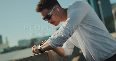 Buy stock photo Runner, music and fitness in city on break, thinking and check smart watch for exercise progress. Earphones, bridge and sports man outdoor for health, wellness and listening to podcast for training