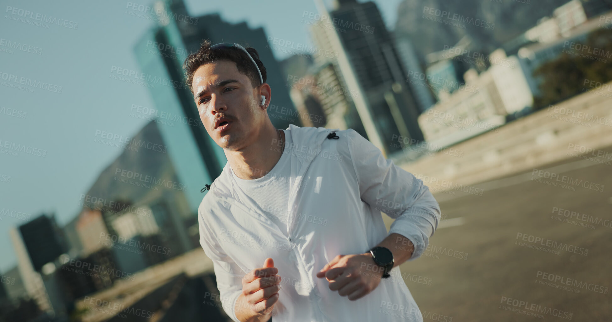 Buy stock photo Fitness, running and man in city with earphones for morning workout, outdoor health and wellness in street. Urban, road and runner with music, commitment to exercise and marathon training challenge