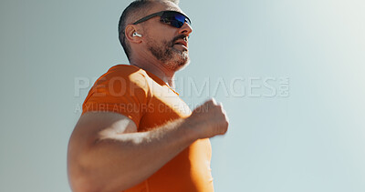 Buy stock photo Man, sky and running with earphones for exercise, streaming music and sunglasses for cardio. Male person, mockup space and athlete for sports workout, hearing audio and outdoor for fitness activity