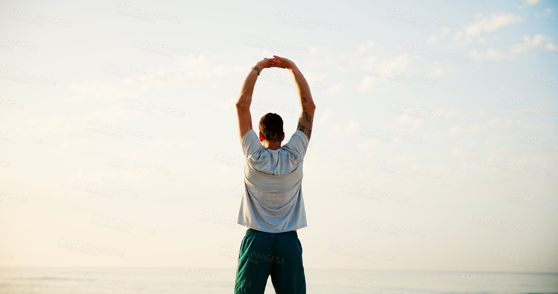 Buy stock photo Man, back and stretching with fitness by beach for workout, breathing exercise or health and wellness in nature. Active, male person or runner with warm up for training or fresh air by ocean coast