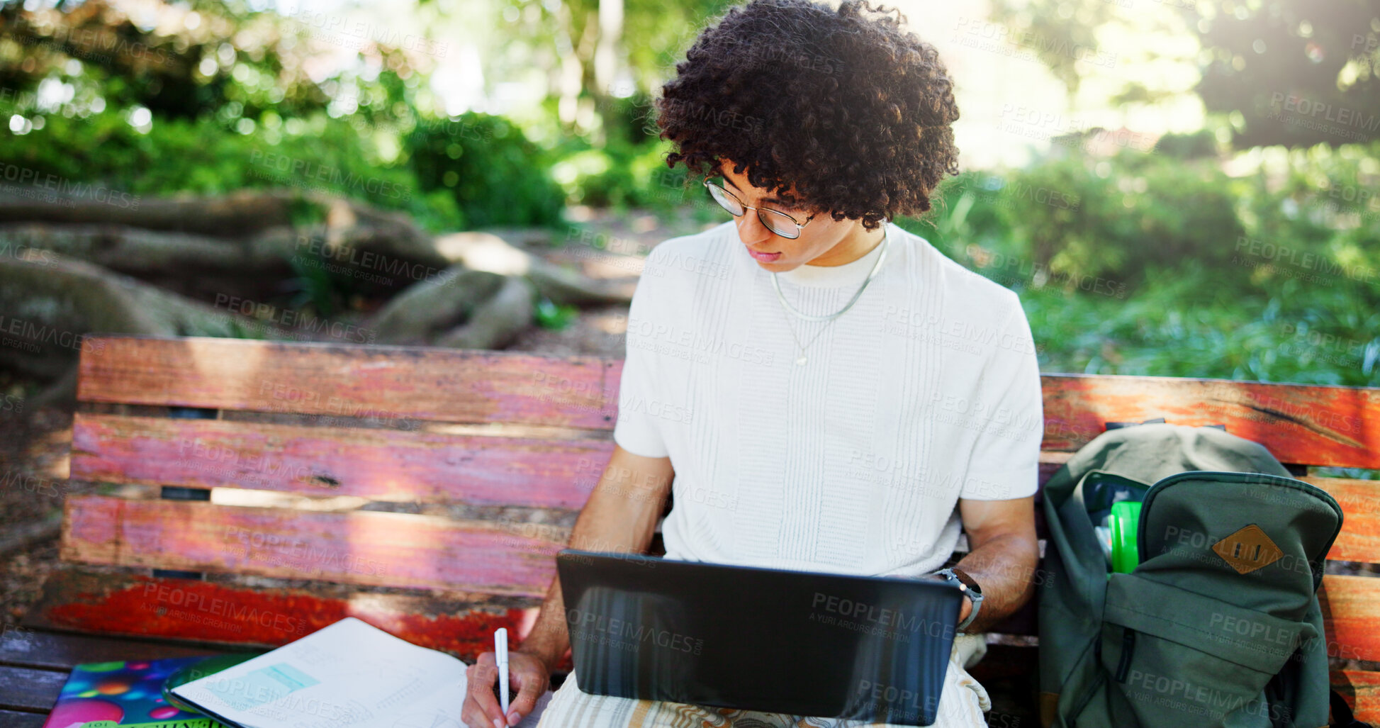 Buy stock photo Man, student and writing notes on park bench, laptop and study with project for online course. Person, computer and e learning for scholarship, exam and education with books for test in Costa Rica