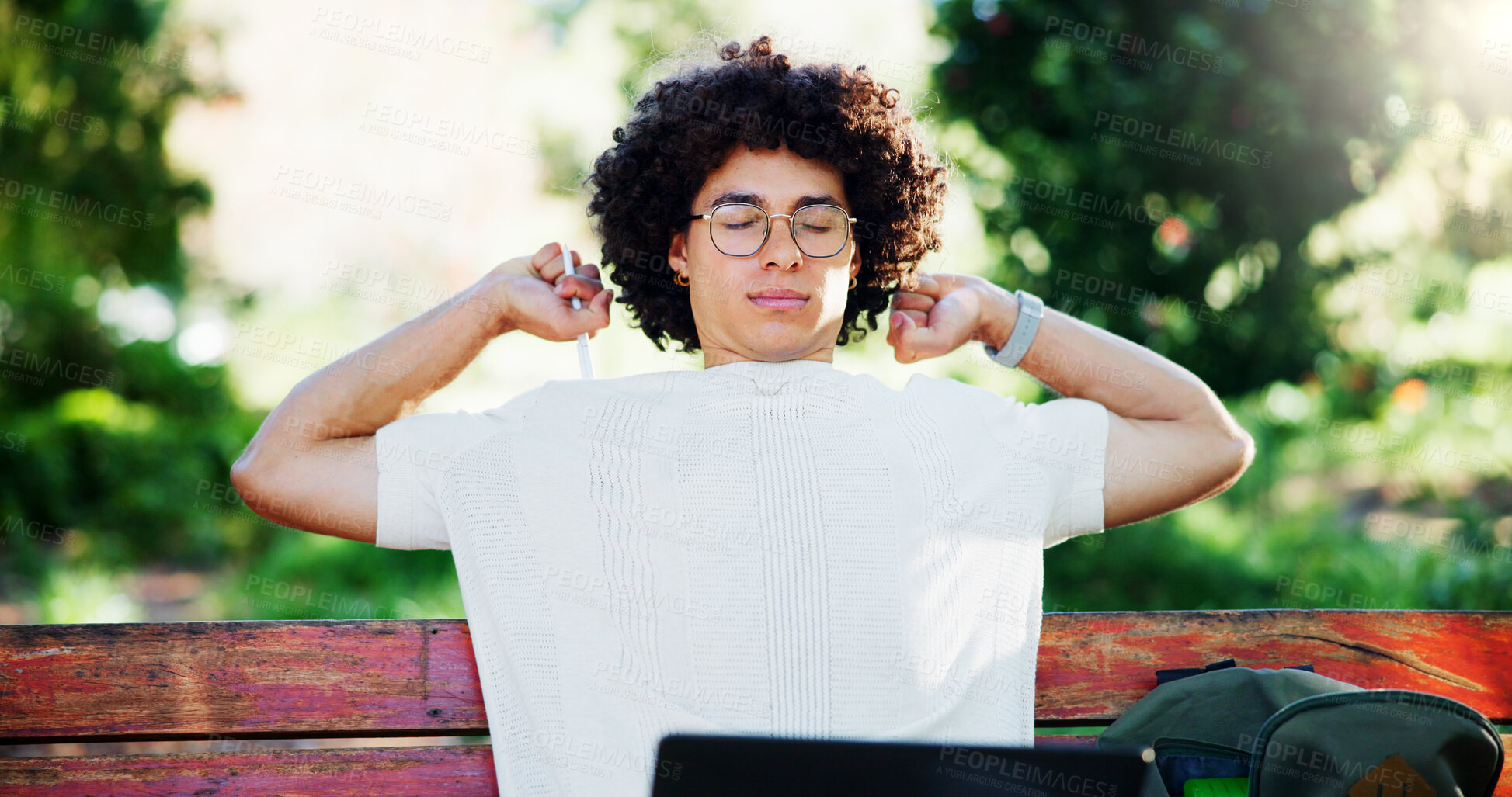 Buy stock photo Tired, student or stretching in park with glasses, burnout or overwhelmed with study research at tech. Fatigue, man or laptop on outdoor bench for university assessment, brain fog or project deadline