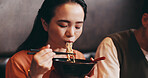 Japanese woman, eating lunch and man in restaurant for date, bonding together and healthy meal. Female person, hospitality and diet with traditional cuisine, chopsticks or ramen noodles as asian food