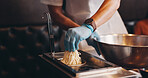 Japan, restaurant and hands boiling noodles for traditional cuisine, culinary culture and meal preparation. Chef, gloves and person steaming ramen in strainer for nutrition, cooking or healthy dinner