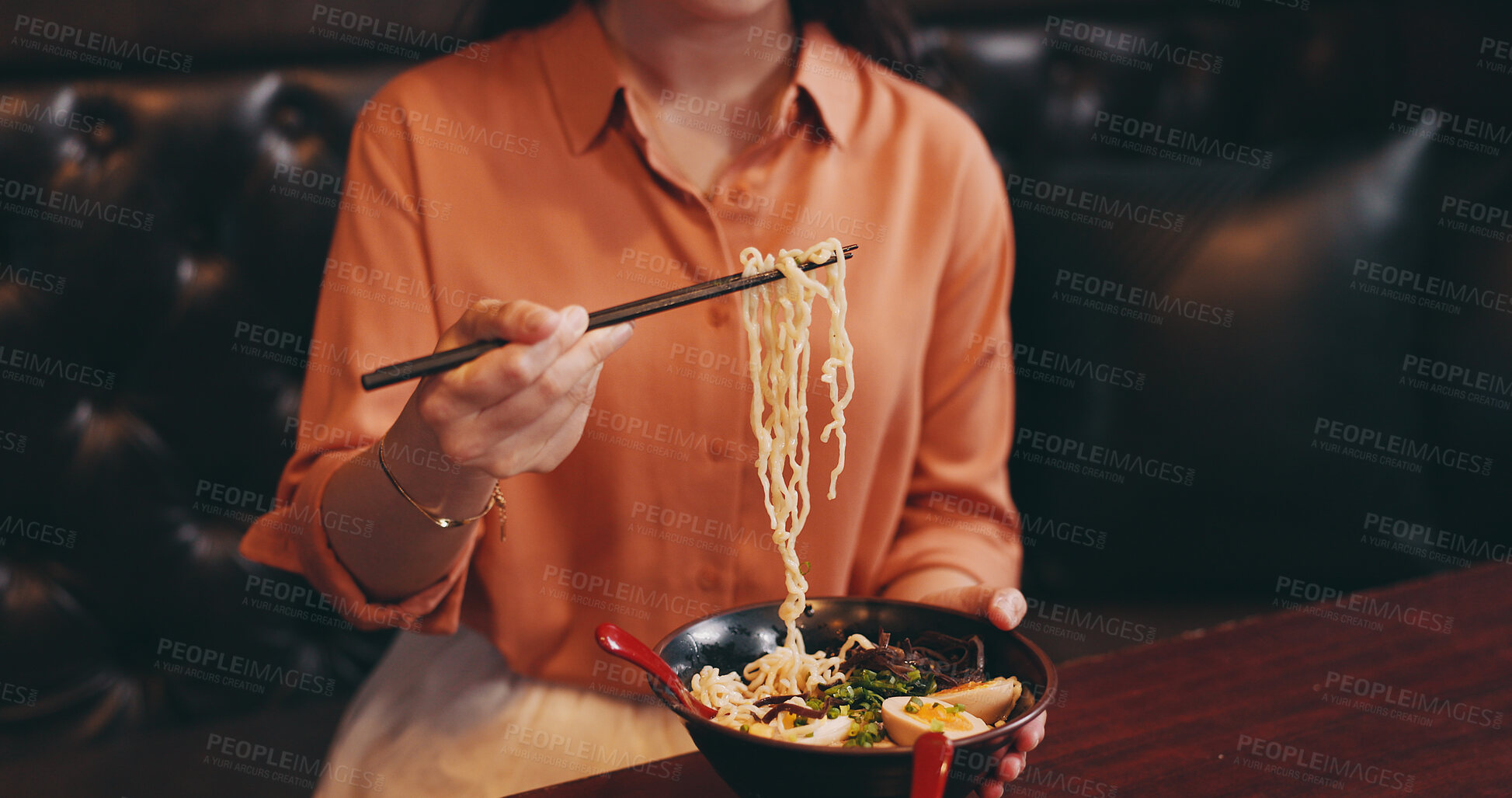 Buy stock photo Hands, woman and eating lunch as hungry in restaurant for nutrition, culture and healthy meal. Female person, hospitality and diet with traditional cuisine, chopsticks and ramen noodles as asian food